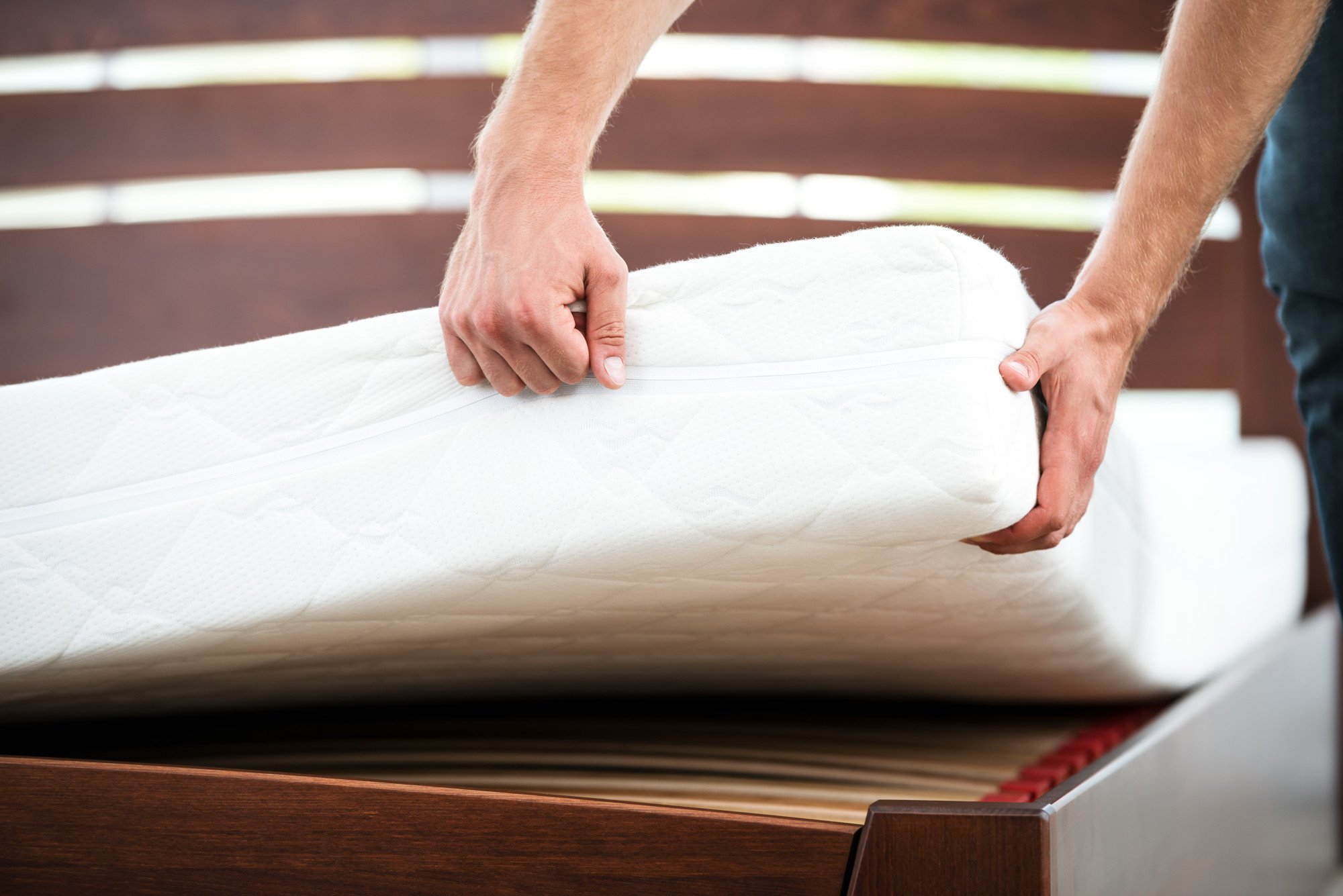 person lifting a mattress and answering the question, how much does a mattress weigh?